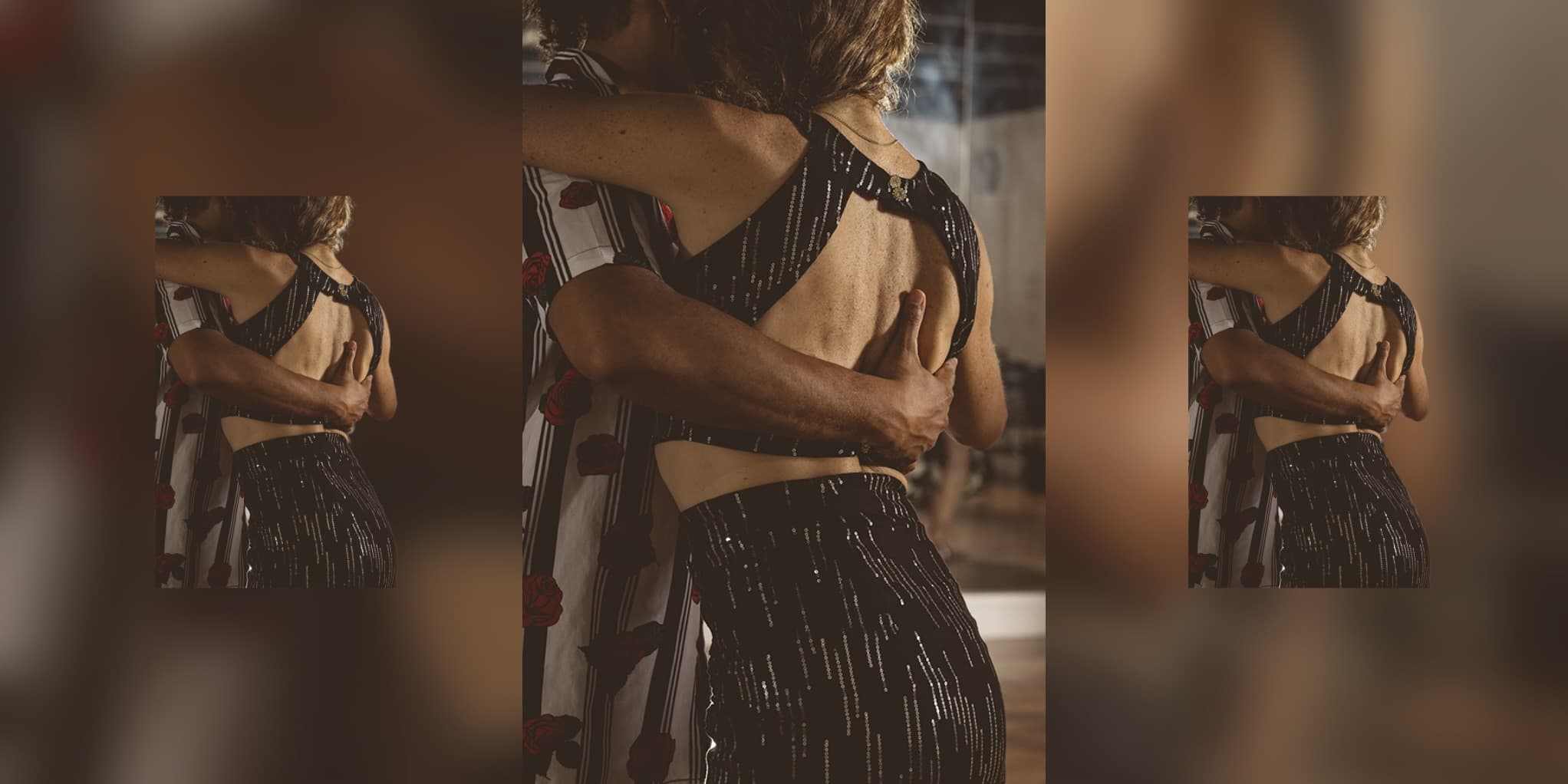 Man in striped rose-print shirt embraces woman in black sequined outfit while dancing closely.